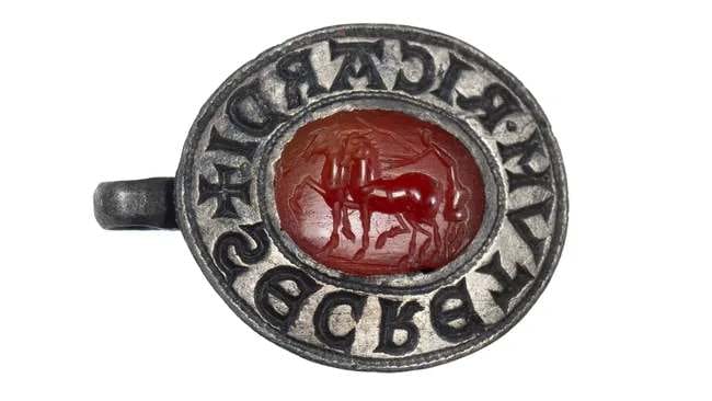 The finely carved Roman gemstone depicts a charioteer standing on a racing chariot, whip in hand, urging on two high-stepping horses.