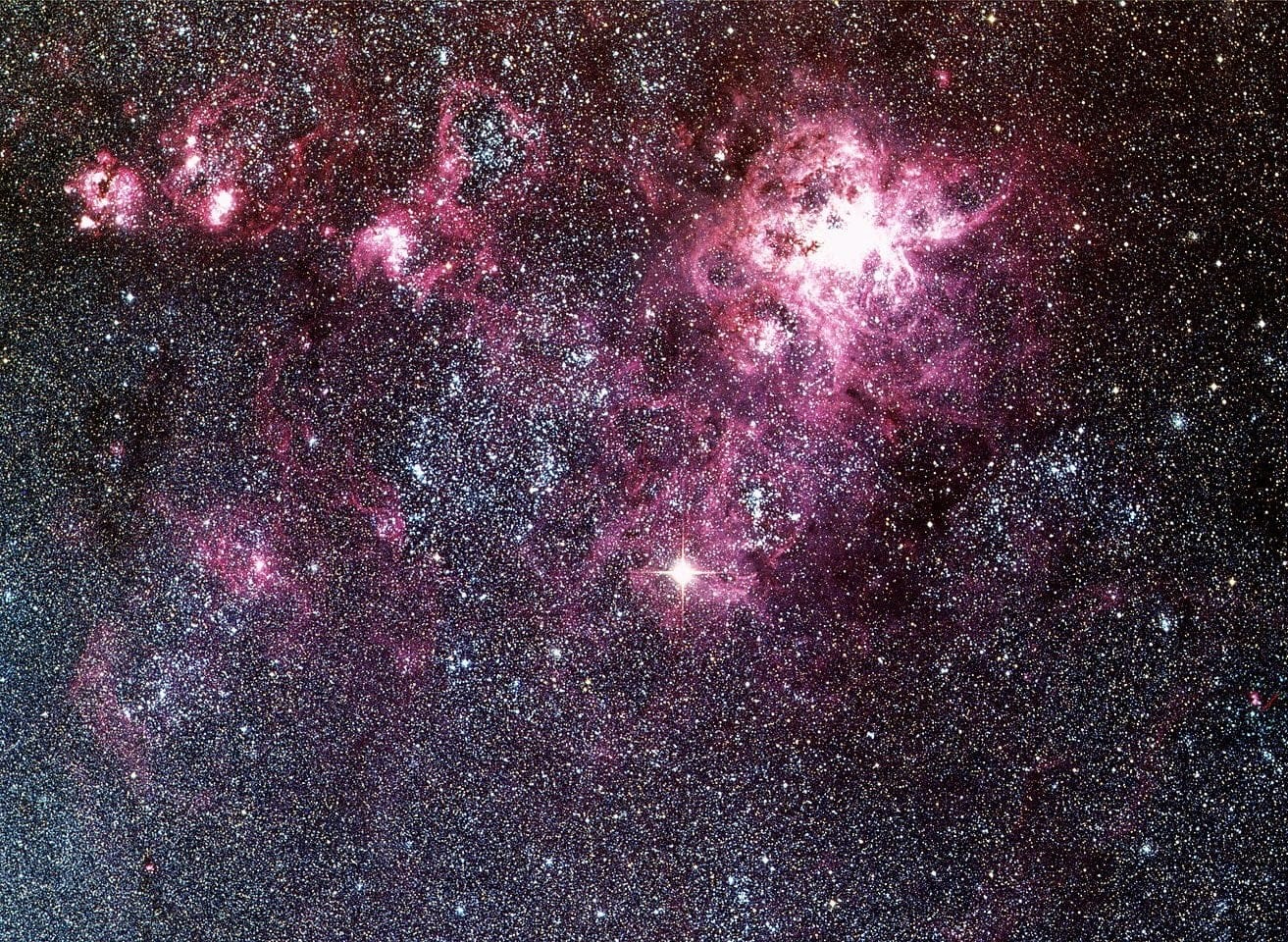 Supernovas como a SN1987A, vistas aqui no centro da imagem, podem ser usadas para medir distâncias no espaço