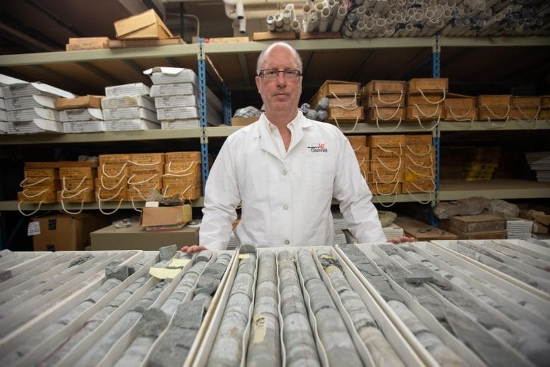 Thomas Algeo Stands in Front of Rock Cores